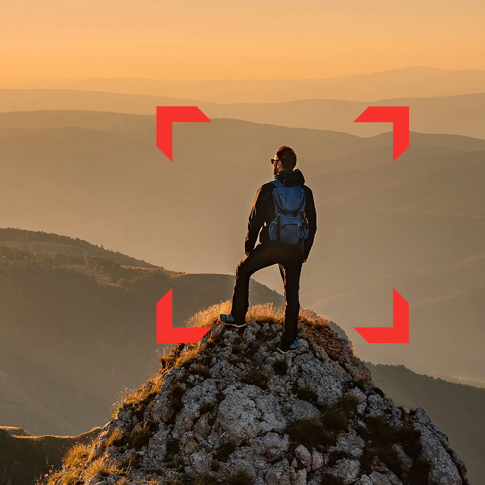 A man standing on top of a mountain thinking about his future